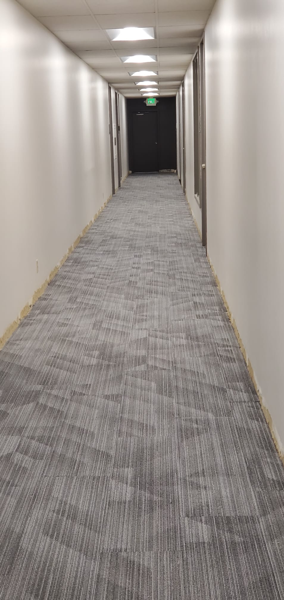 Gray carpet tile flooring along an empty hallway